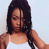 a woman with long dreadlocks is taking a selfie